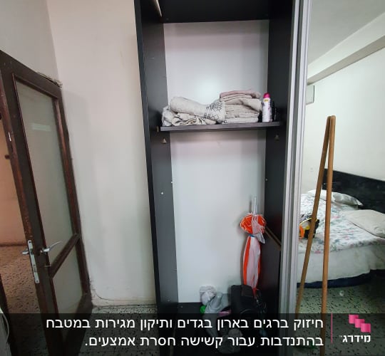 ארון פתוח עם מגבות, מטאטא וכלי עבודה שונים